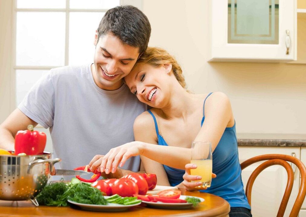 mulher e homem preparando legumes para aumentar a potência